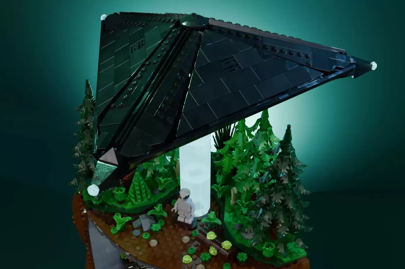 LEGO recreation of Mulder's basement office with minifigure, desk, filing cabinets, forest backdrop, and solar panel roof.