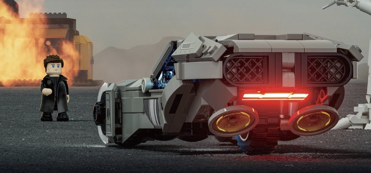 LEGO K minifigure beside illuminated Spinner vehicle with glowing red details and weapon, explosion backdrop.