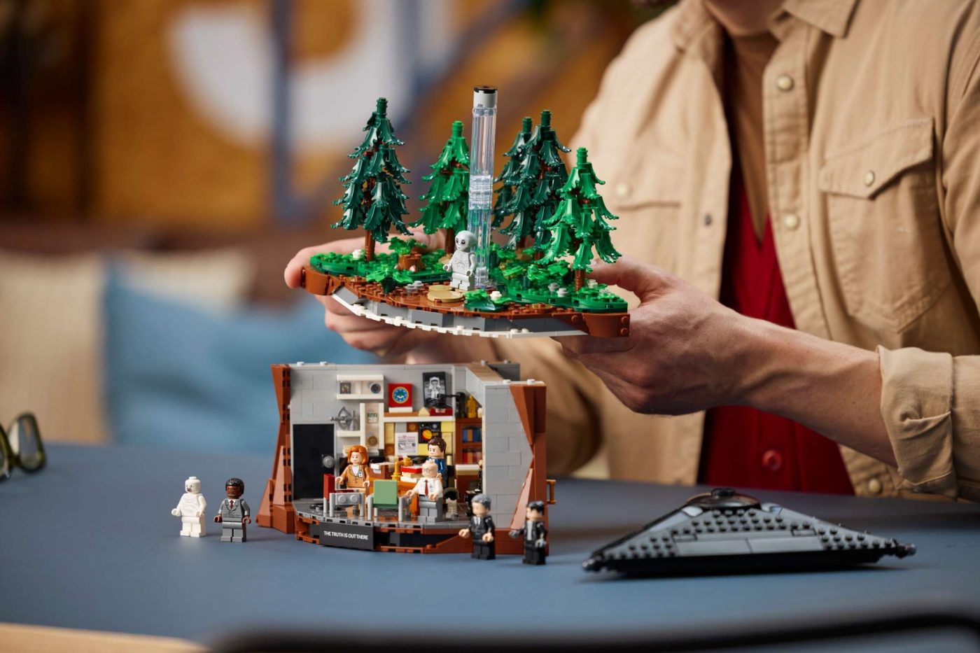 LEGO Ideas The X-Files Set 21369 displayed with cabin and forest sections held in hands.