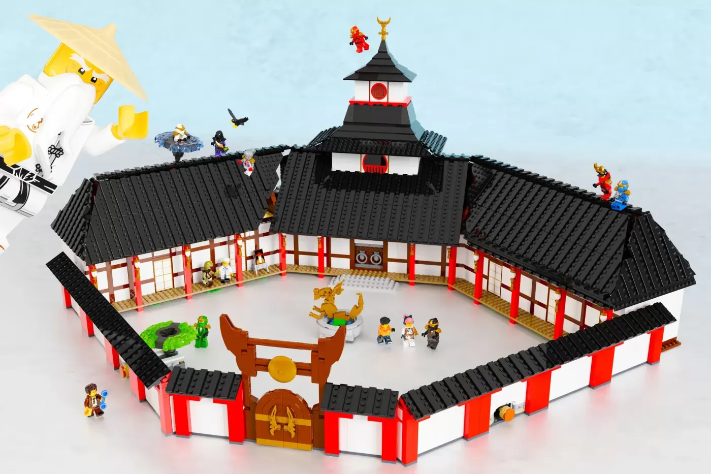 LEGO Ninjago Monastery with black tile roofs, red and white walls, central courtyard, golden dragon statue, and minifigures.
