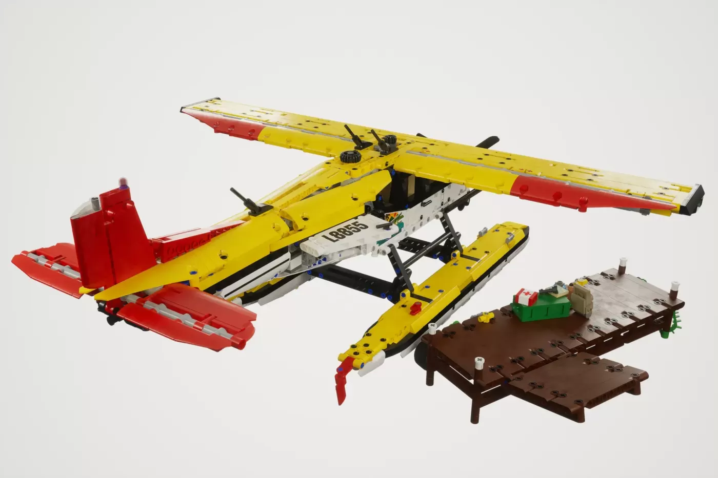 LEGO Cessna 185 float plane model with yellow wings, red floats, and brown dock base with accessories.