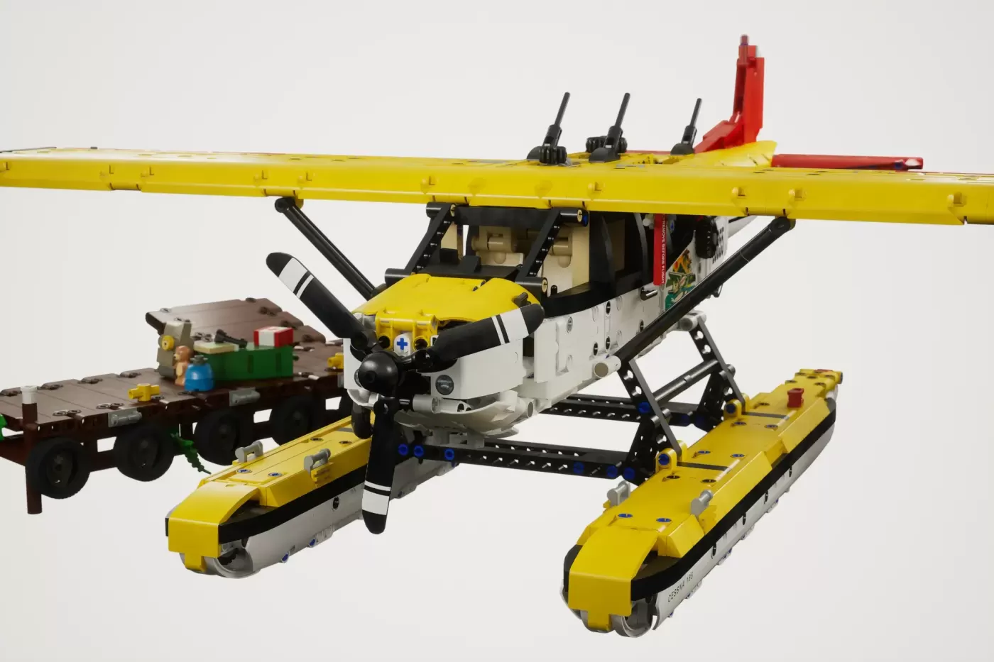 LEGO Cessna 185 float plane with yellow fuselage, floats, and support structure; includes minifigures and cargo.