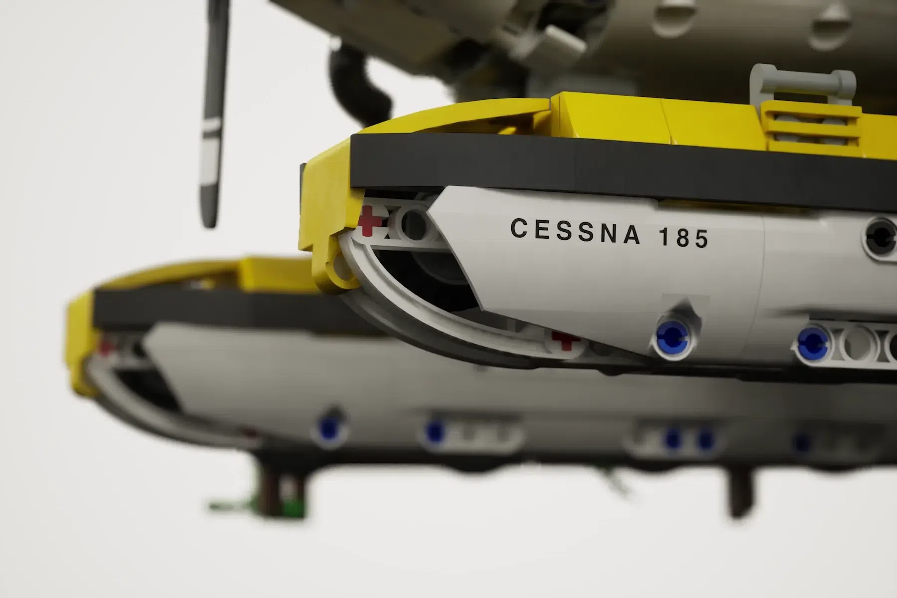 LEGO Cessna 185 float plane model with yellow and white fuselage, detailed cockpit, and blue floats visible.