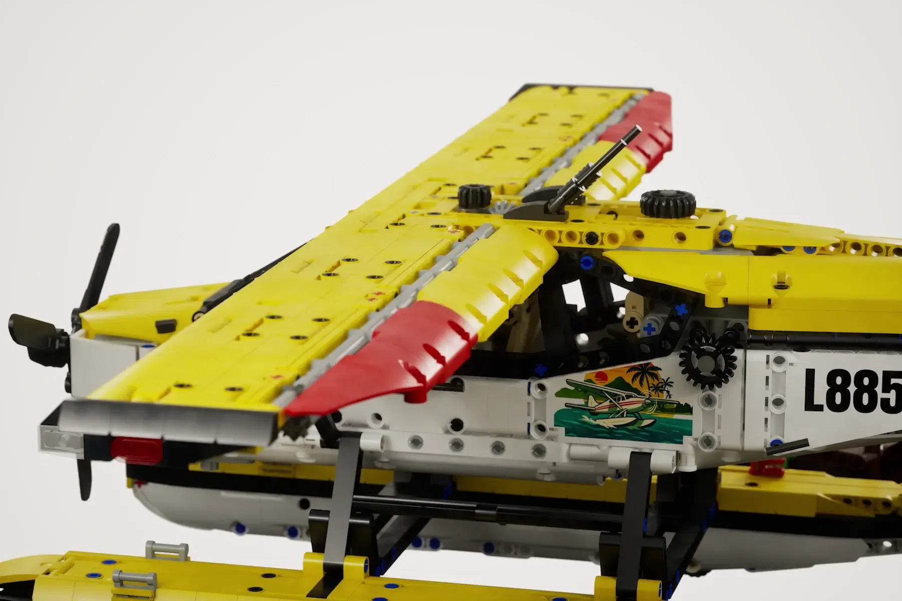 LEGO Cessna 185 float plane model L885 with yellow wings, red accents, and detailed cockpit against white background.