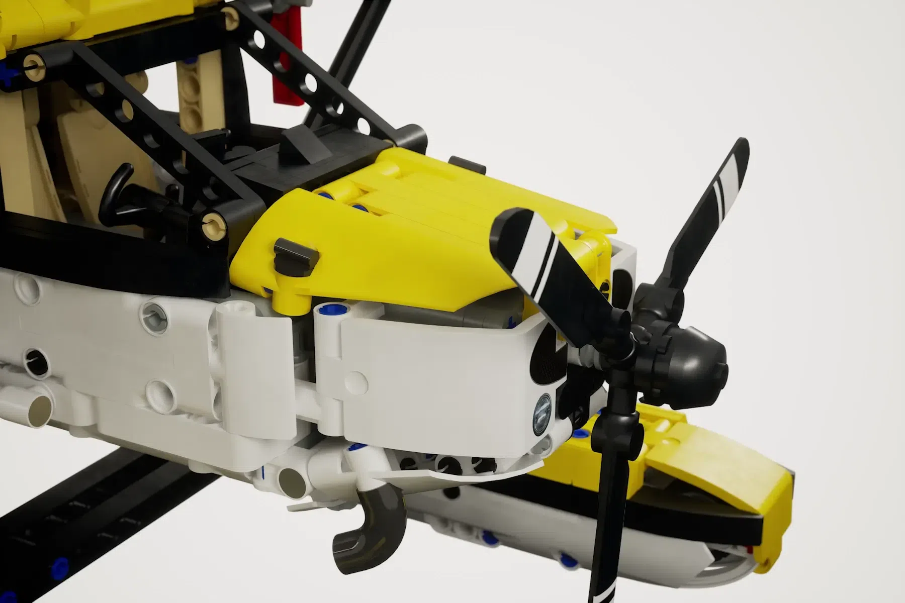 Yellow and white LEGO Cessna 185 float plane with black propeller and landing gear details.